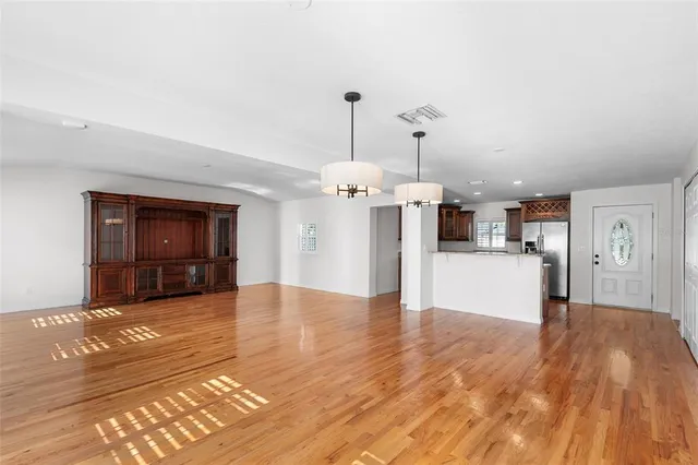 a view of empty room with wooden floor
