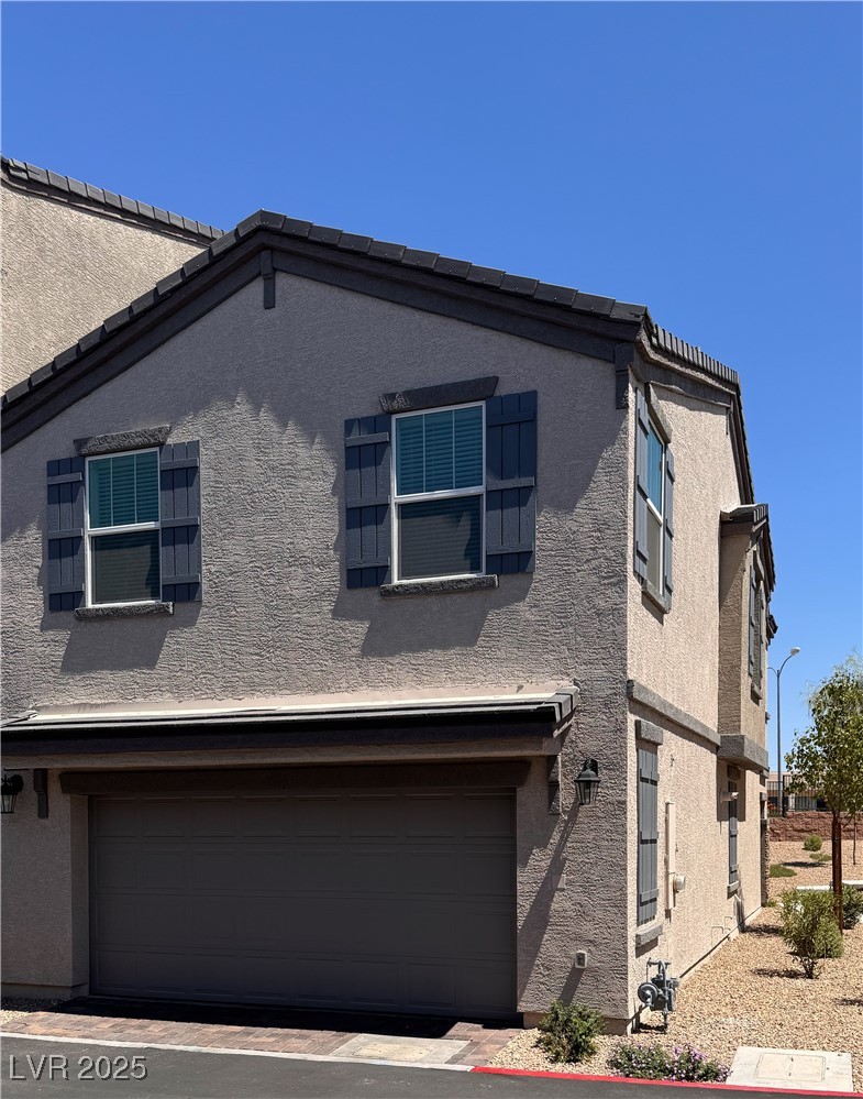 662 Foam Flower Lane Henderson, NV 89015 - Photo 13 of 14 View of back of home with an attached garage and stucco siding