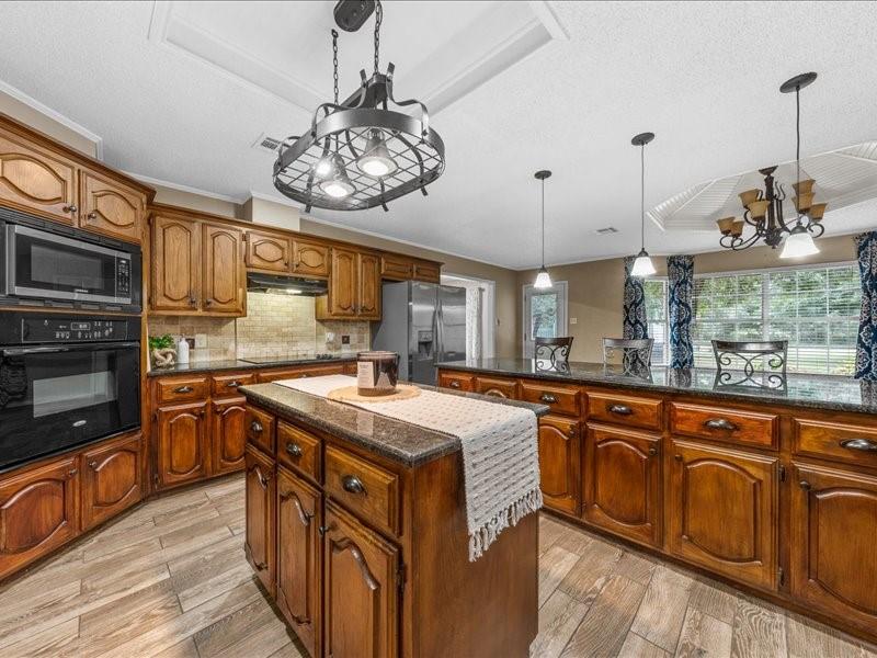 1072 Chapman Road Crawford, TX 76638 - Photo 8 of 39 a kitchen with stainless steel appliances granite countertop a sink and stove top oven
