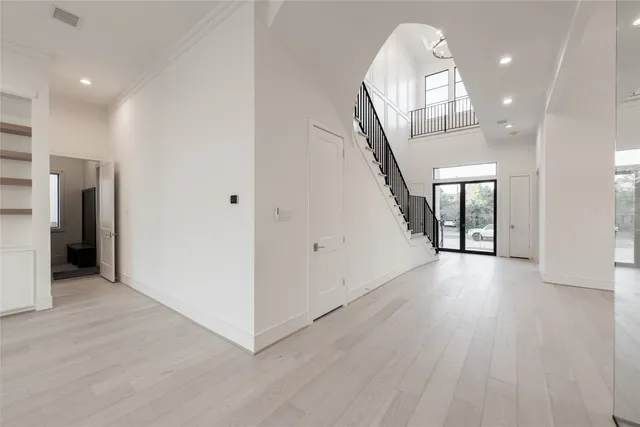 an empty room with wooden floor and a large window