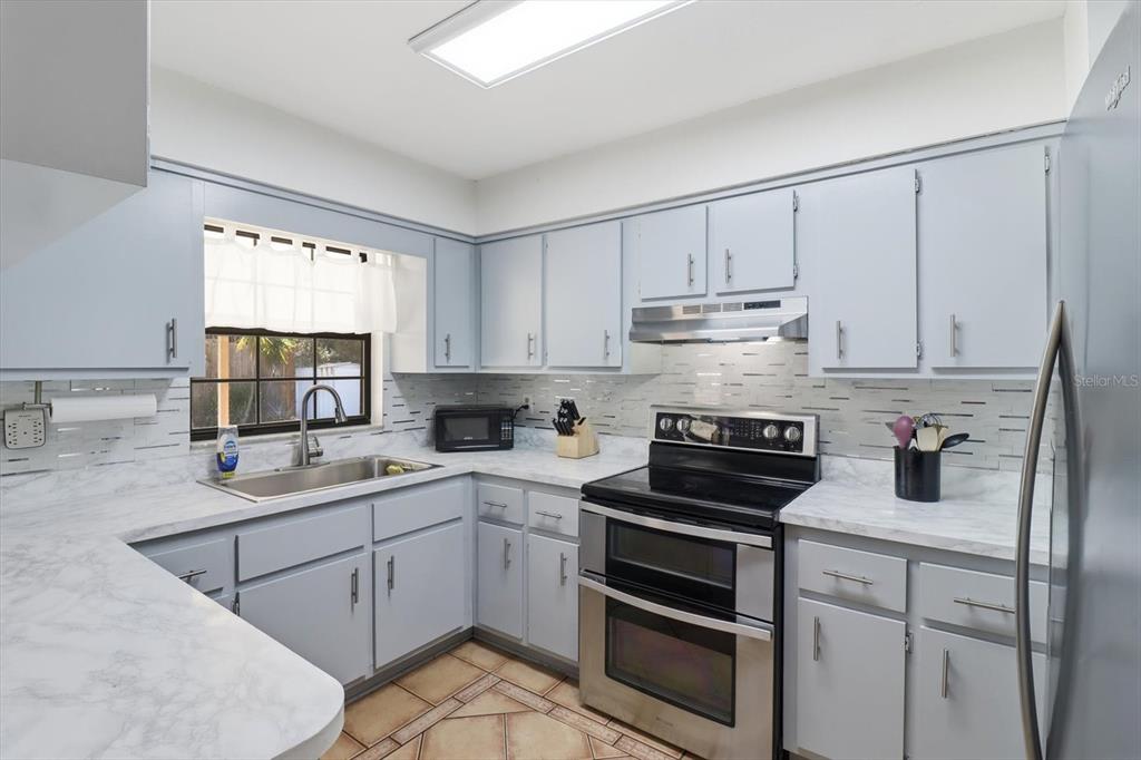 6940 Southeast 52nd Street Ocala, FL 34472 - Photo 13 of 45 a kitchen with a sink stove top oven and cabinets