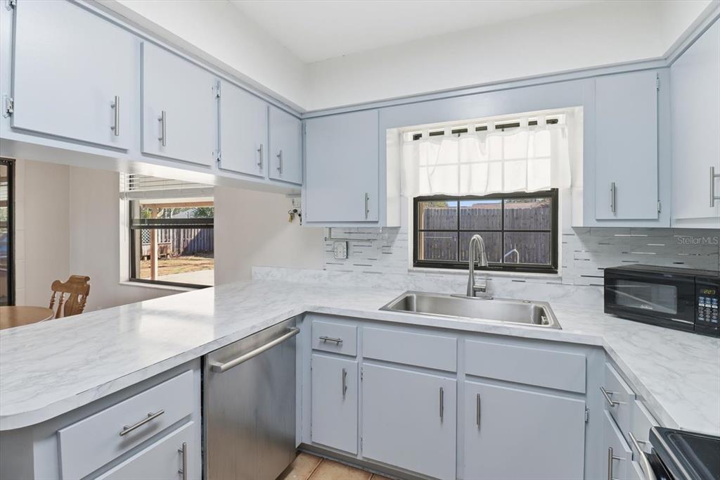 6940 Southeast 52nd Street Ocala, FL 34472 - Photo 14 of 45 a kitchen with white cabinets and a sink