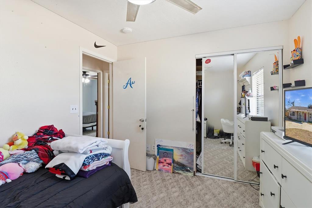 6940 Southeast 52nd Street Ocala, FL 34472 - Photo 22 of 45 a bedroom with a bed and a chandelier