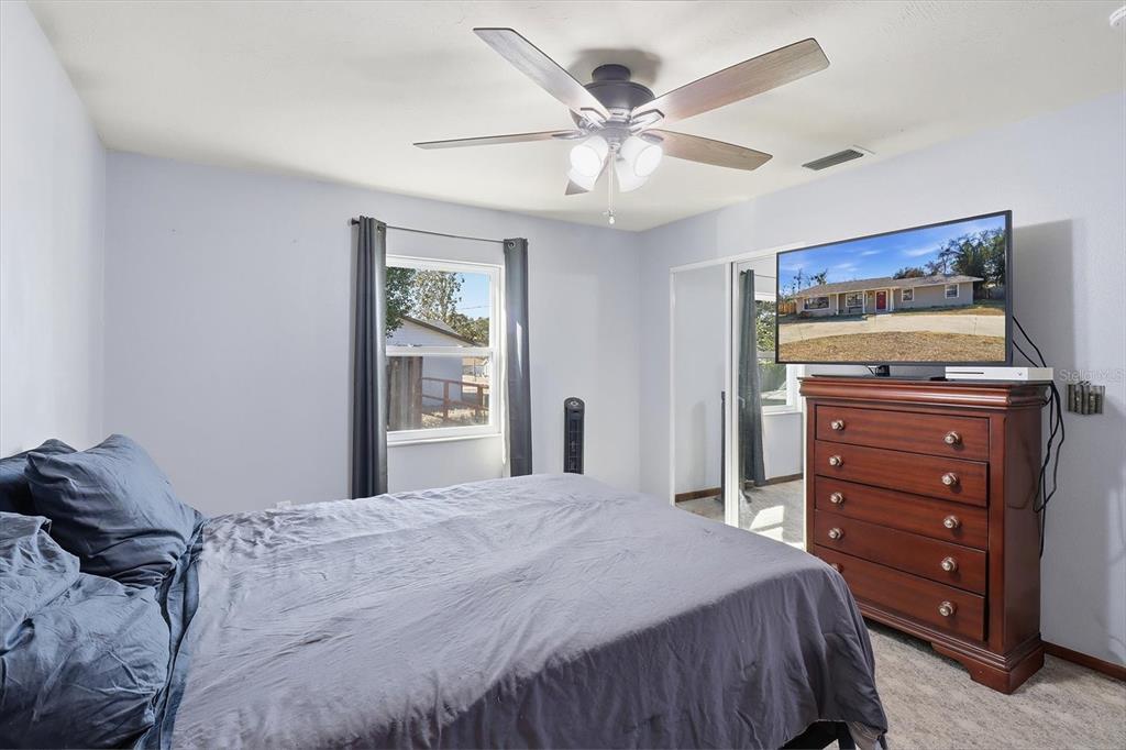 6940 Southeast 52nd Street Ocala, FL 34472 - Photo 26 of 45 a bedroom with a bed and a chandelier