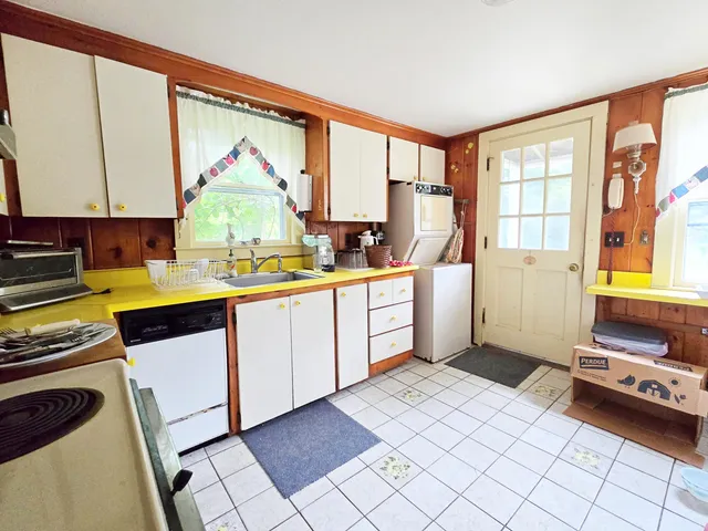 a kitchen with a sink appliances cabinets and a window
