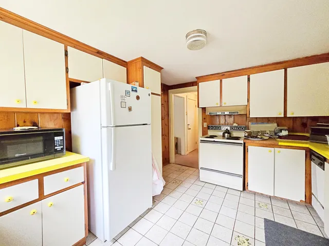 a kitchen with a refrigerator a stove top oven and a large window