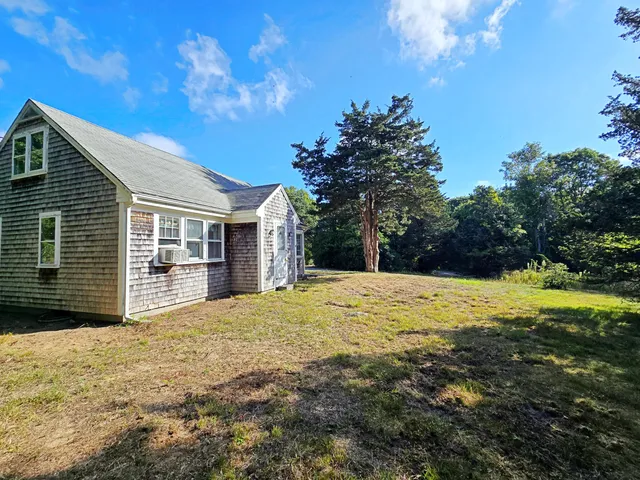 a view of a house with backyard and trees