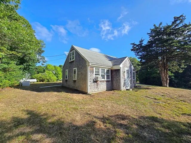 a view of a house with a yard and large tree