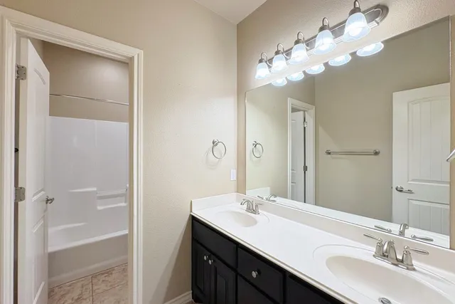 a bathroom with a double vanity sink and a mirror