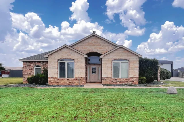 a front view of house with yard and green space
