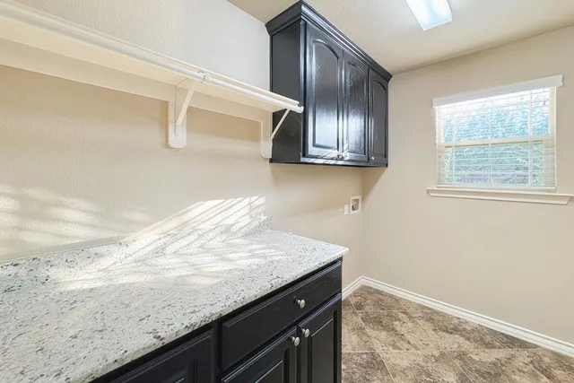 a view of kitchen with granite countertop cabinets and refrigerator