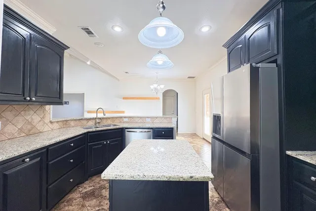 a kitchen with stainless steel appliances granite countertop a sink refrigerator and cabinets