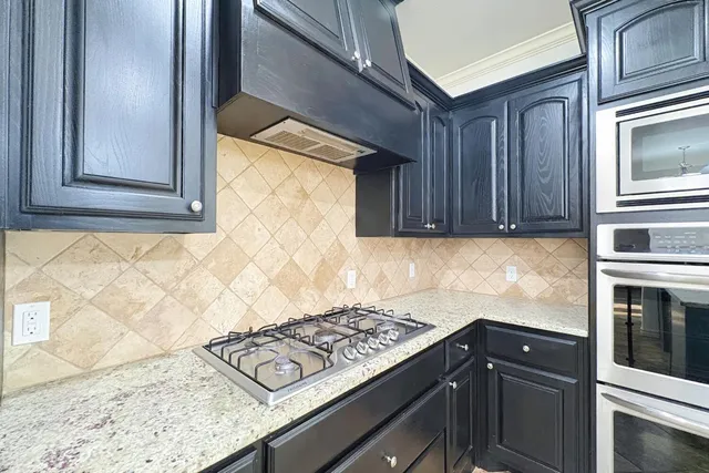 a kitchen with granite countertop cabinets stainless steel appliances and a counter space
