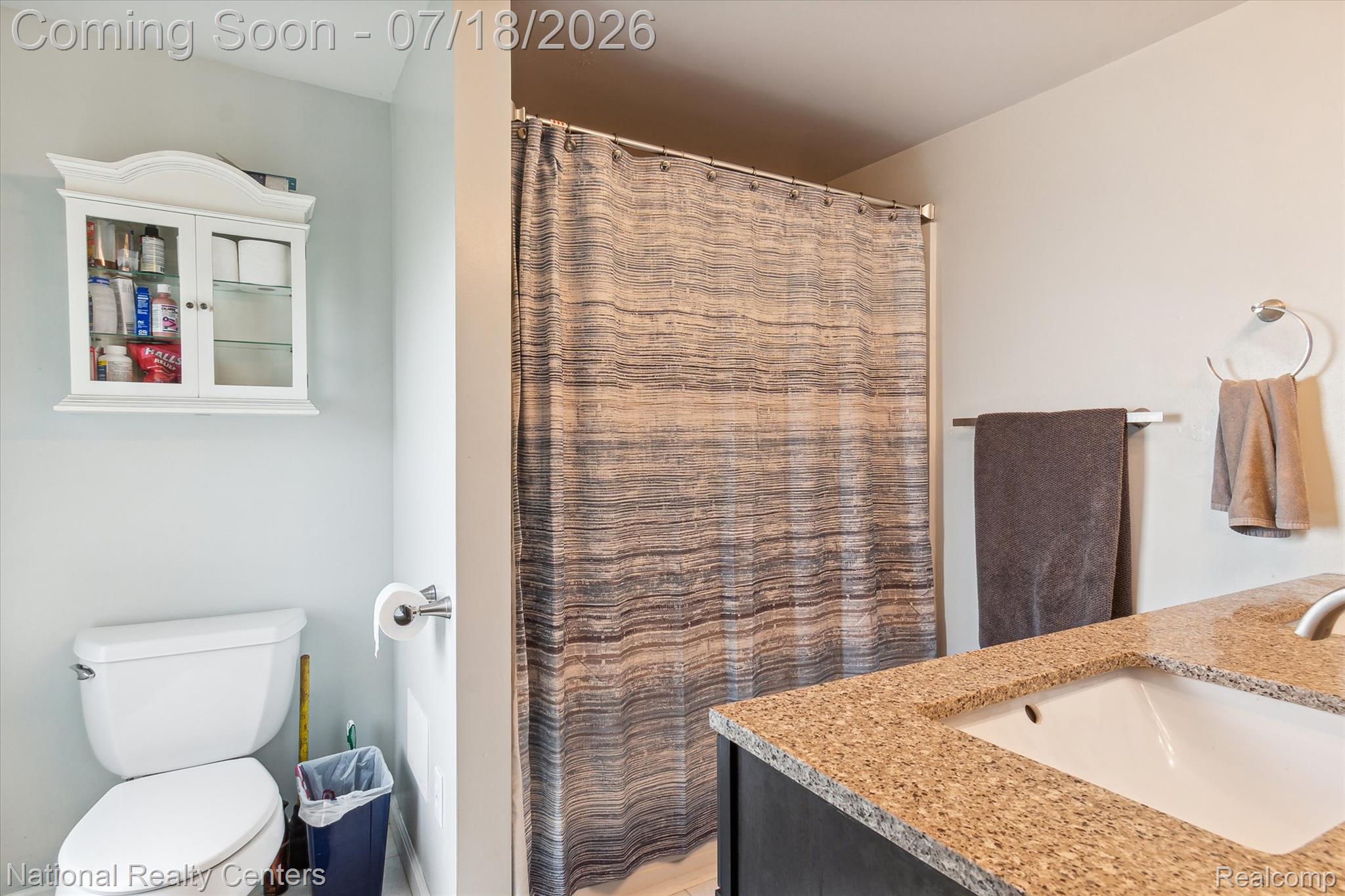 9589 Clinton Macon Road Tecumseh, MI 49286 - Photo 25 of 48 Bathroom featuring a white toilet, wall-mounted medicine cabinet, shower with a curtain, and a vanity with a light-colored countertop