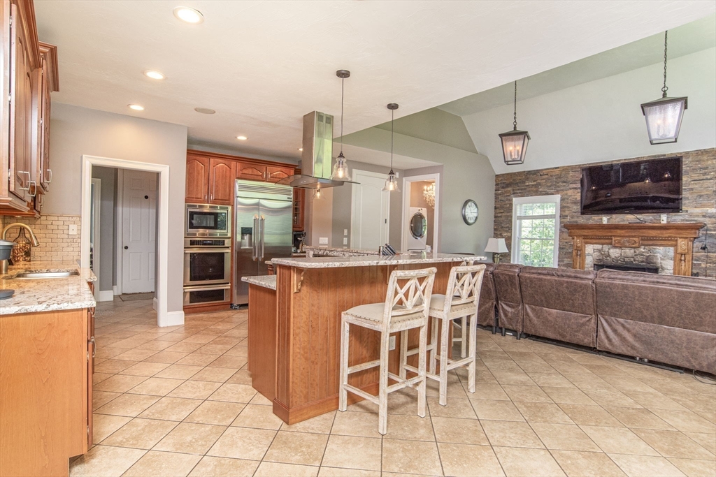 19 Round Farm Road Rehoboth, MA 02769 - Photo 12 of 42 a dining hall with stainless steel appliances kitchen island granite countertop a table and chairs