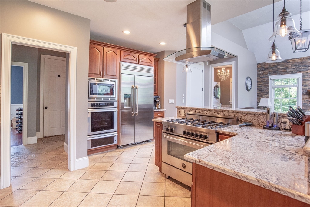 19 Round Farm Road Rehoboth, MA 02769 - Photo 14 of 42 a kitchen with kitchen island granite countertop a stove a sink and a refrigerator