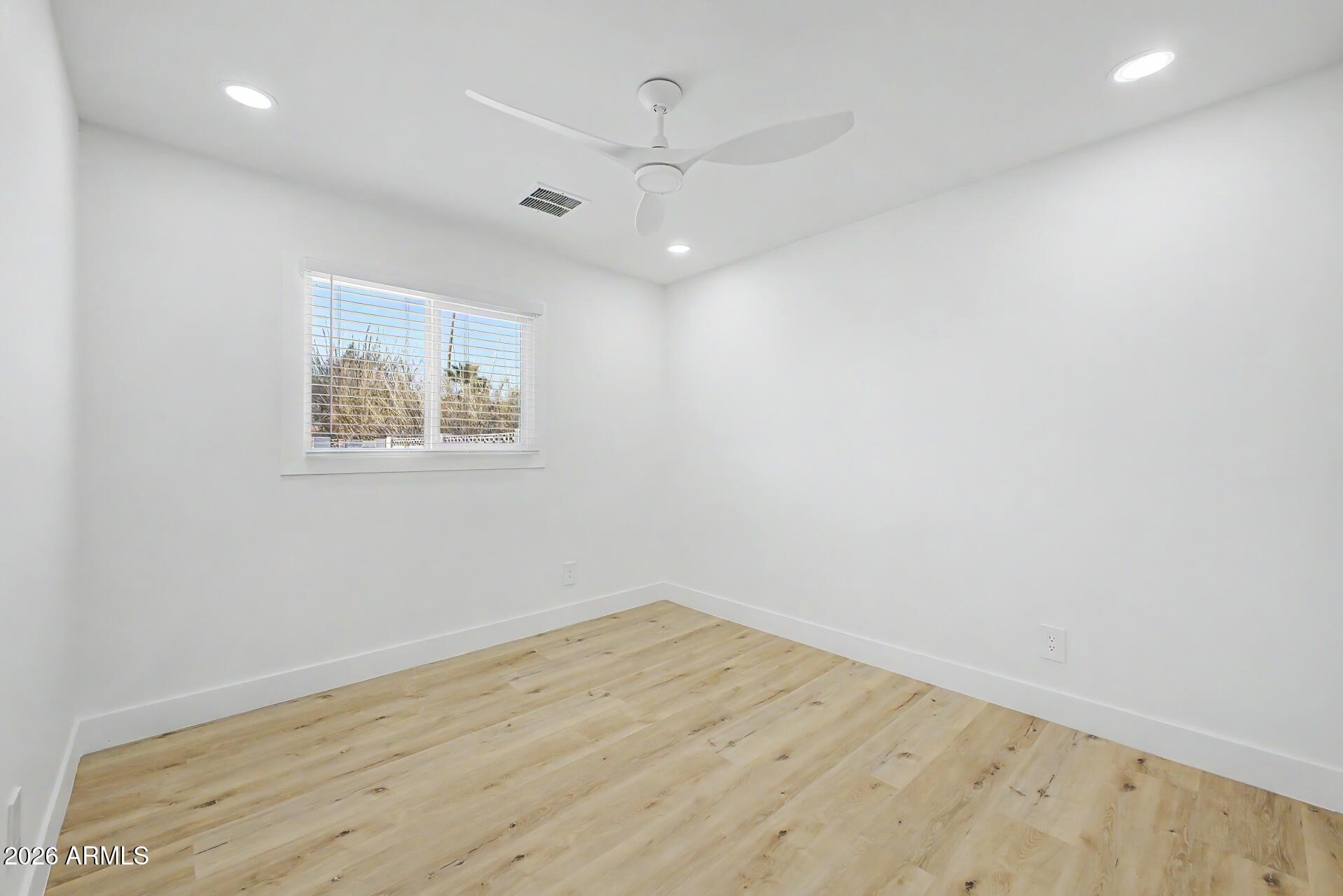 5232 West Hearn Road Glendale, AZ 85306 - Photo 16 of 32 an empty room with wooden floor and windows
