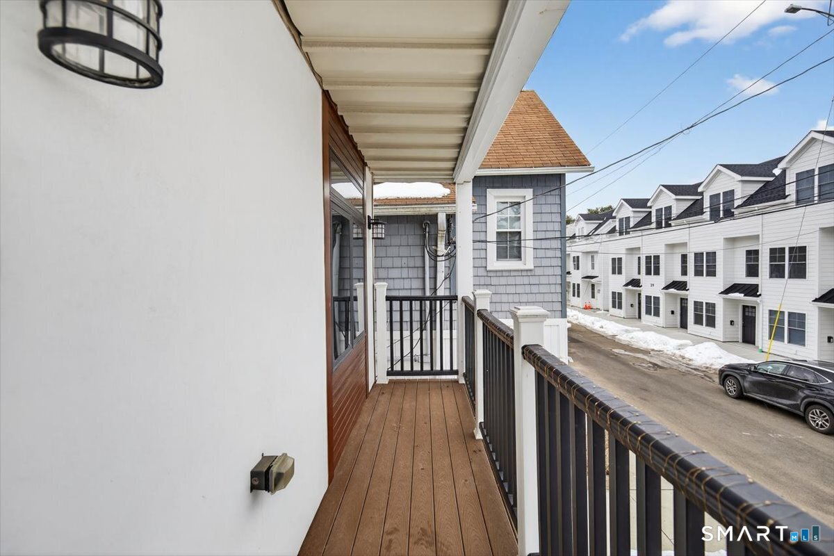 32 1/2 Village Road, Unit 1 Milford, CT 06460 - Photo 22 of 31 a view of a porch with wooden floor and fence