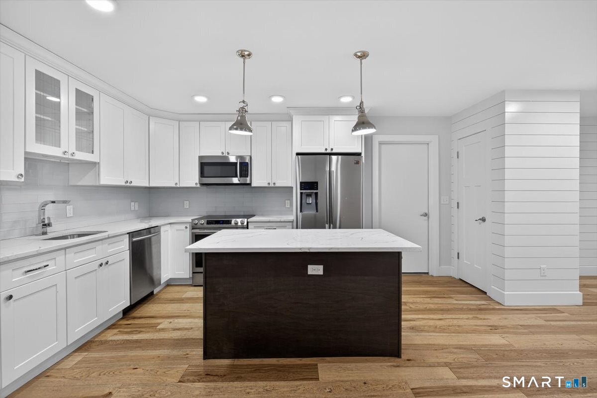 32 1/2 Village Road, Unit 1 Milford, CT 06460 - Photo 4 of 31 a kitchen with kitchen island a sink dishwasher a refrigerator and white cabinets