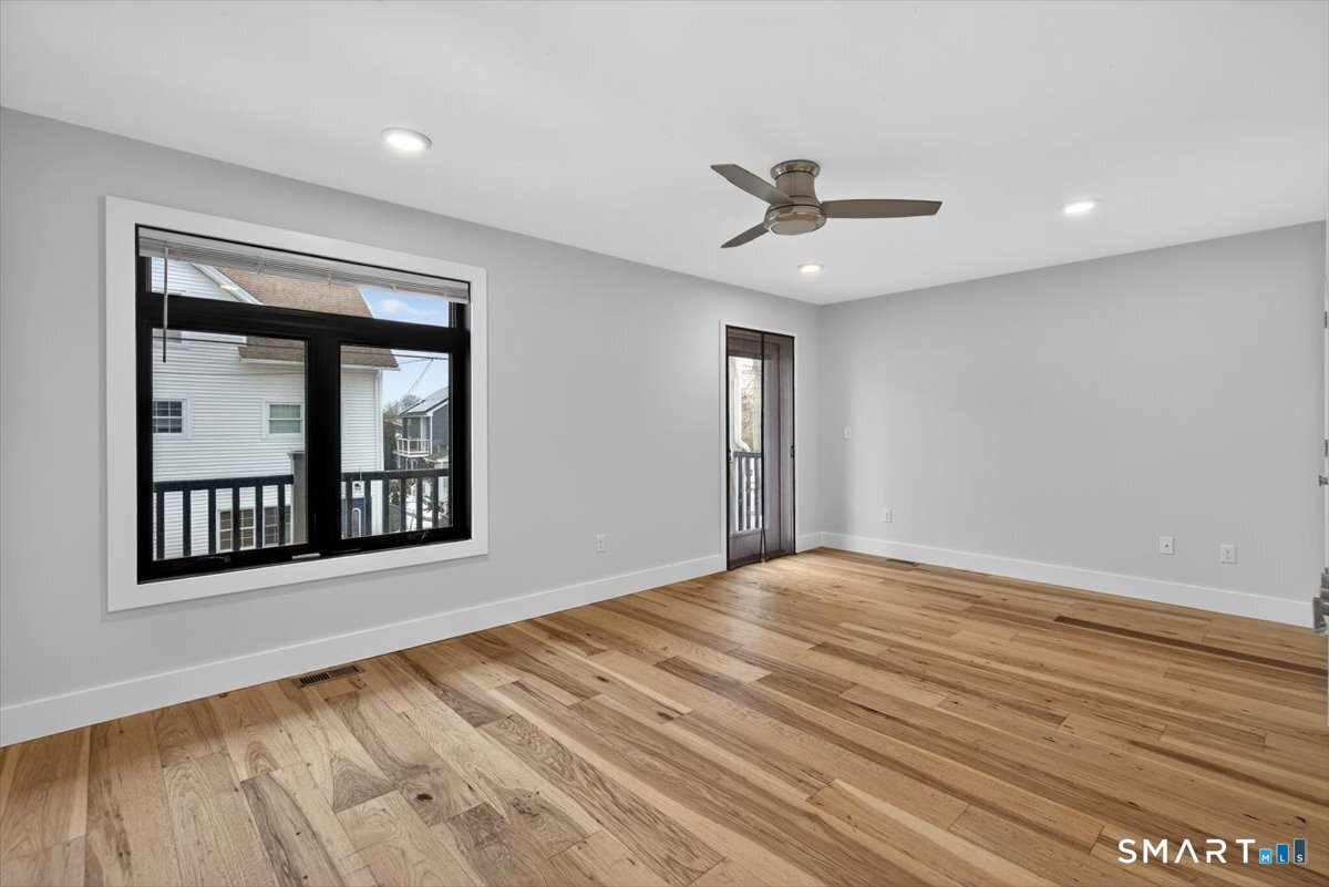 32 1/2 Village Road, Unit 1 Milford, CT 06460 - Photo 10 of 31 a view of an empty room with a window and wooden floor