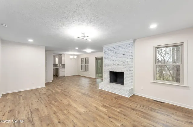 a view of a livingroom with a fireplace and window