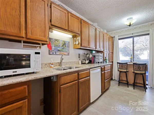 a kitchen with granite countertop a sink stove and cabinets