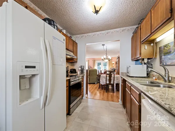 a kitchen with stainless steel appliances granite countertop a refrigerator and a sink