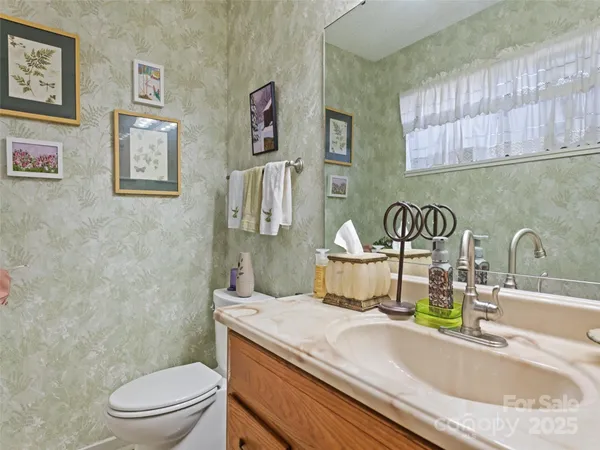 a bathroom with a granite countertop toilet sink and mirror