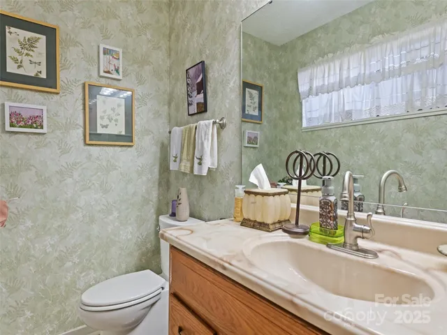 a bathroom with a granite countertop toilet sink and mirror