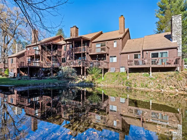 a front view of a building with swimming pool and outdoor seating