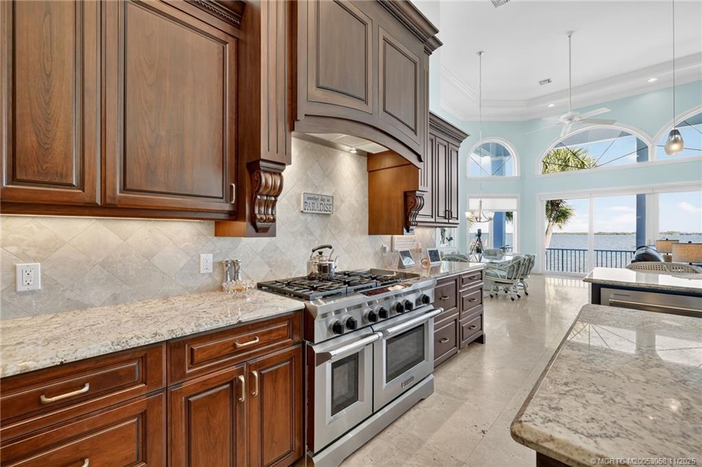 70 North Sewalls Point Road Stuart, FL 34996 - Photo 23 of 72 a kitchen with stainless steel appliances granite countertop a stove a sink and a microwave
