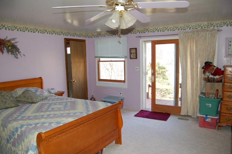 223 Main Road Monterey, MA 01245 - Photo 9 of 10 a bedroom with a bed and a chandelier