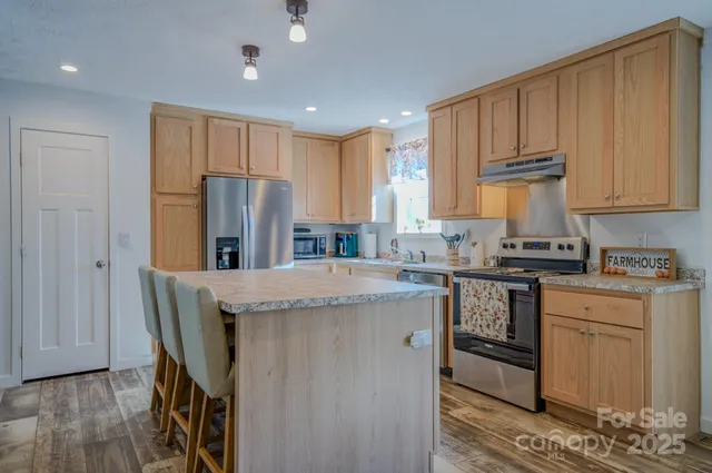 a kitchen with kitchen island granite countertop wooden cabinets and white appliances