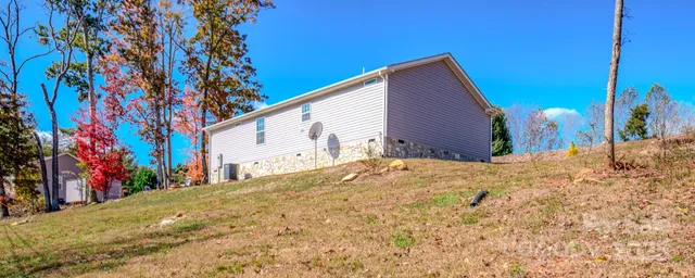 a view of a house with backyard and a tree