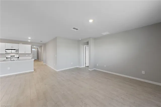 a view of an empty room with a kitchen
