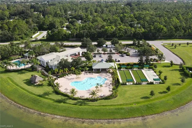 an aerial view of a residential houses with outdoor space and trees