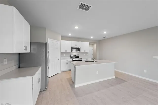 a kitchen with stainless steel appliances kitchen island sink refrigerator and stove