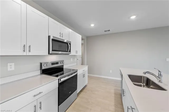 a kitchen with a sink a stove and microwave