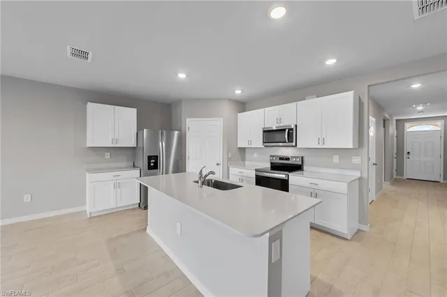 a kitchen with white cabinets and stainless steel appliances
