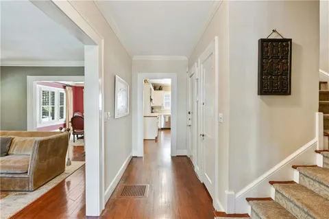 a view of a hallway with wooden floor and staircase