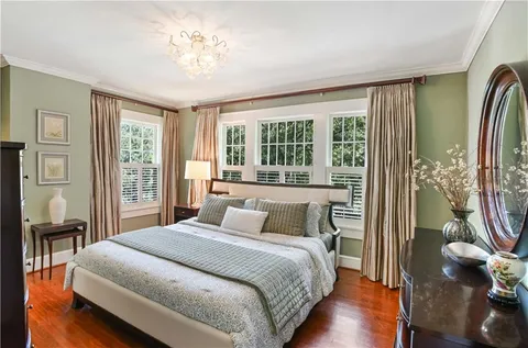 a bedroom with a large bed and a chandelier