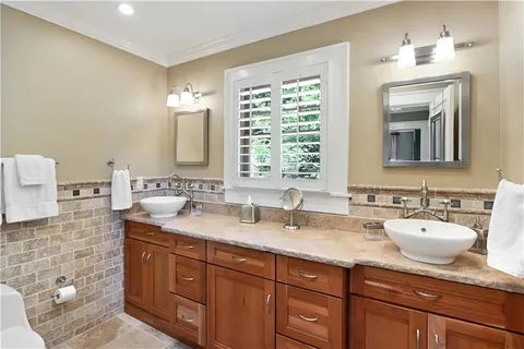 a bathroom with a granite countertop sink a toilet and shower