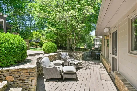 a view of a patio with table and chairs potted plants and large tree