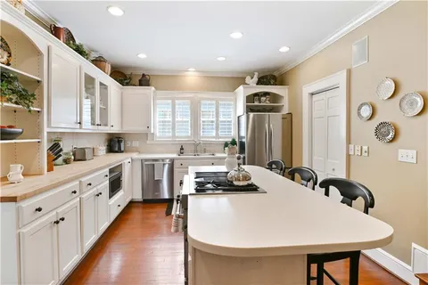 a kitchen with sink a stove and chairs