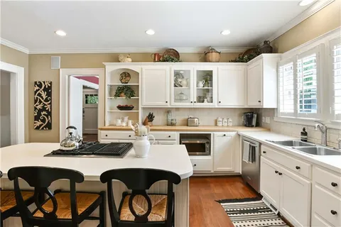 a kitchen with a table chairs sink and cabinets