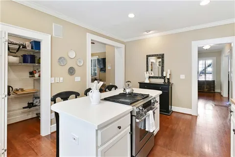 a kitchen that has a stove and a wooden floor