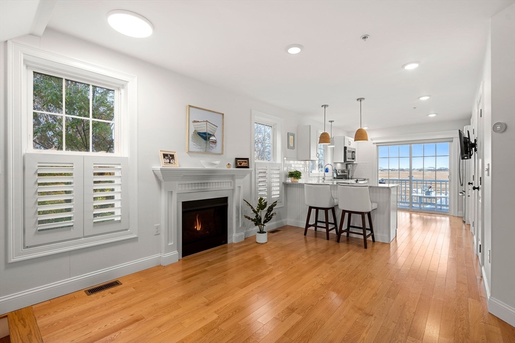 45 Old County Road, Unit 1 Salisbury, MA 01952 - Photo 8 of 40 a living room with furniture a fireplace and kitchen view