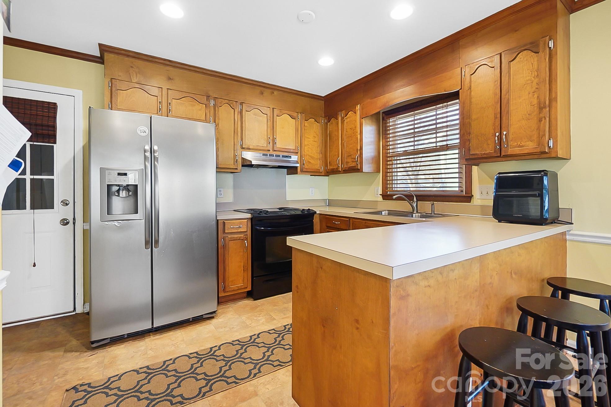 6906 Streamside Drive Charlotte, NC 28212 - Photo 14 of 48 a kitchen with stainless steel appliances granite countertop a sink stove and refrigerator
