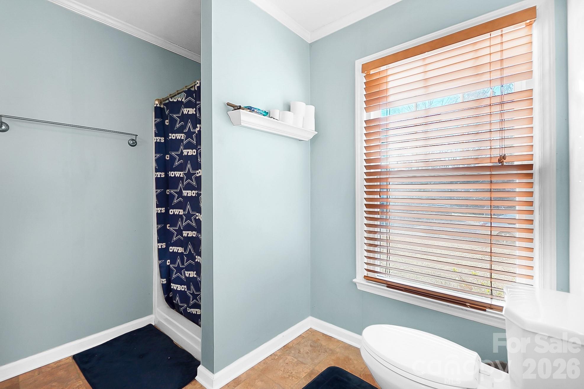 6906 Streamside Drive Charlotte, NC 28212 - Photo 22 of 48 a bathroom with a shower curtain and a window
