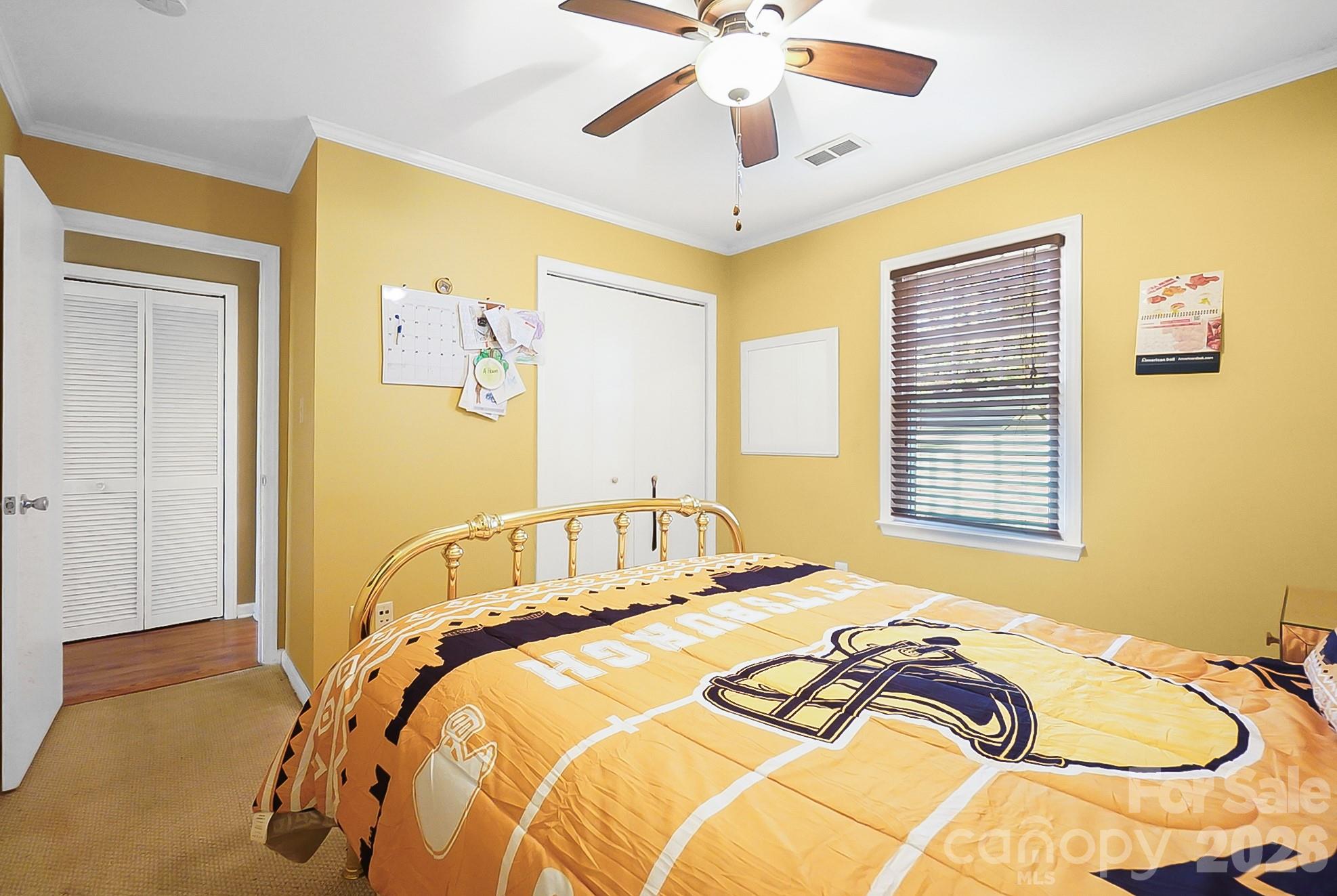 6906 Streamside Drive Charlotte, NC 28212 - Photo 30 of 48 a bedroom with a bed and a chandelier